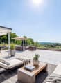 Outdoor terrace with a dining table, chairs, lounge chairs, a coffee table, a canopy, and potted plants.
