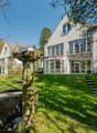 Modern house, white exterior, large windows, balcony, garden, fountain, lawn