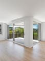 Open floor plan, wooden flooring, large windows, sliding glass doors, balcony with railing