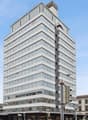 High-rise office building with glass facade, multiple floors, modern architecture, located in an urban area