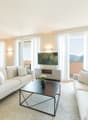 modern living room, two sofas, center table, TV, large windows, wooden floor