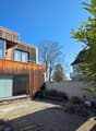 modern wooden house, large windows, balcony, patio, garden