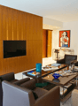 modern living room, wooden wall, flat screen TV, coffee table, armchairs, couch