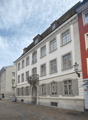 3 story building, white paint, balcony, windows, front door
