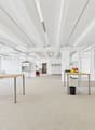 empty room, metal tables, trash bin, lamps, glass windows, white walls