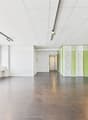 empty room, grey tiled floor, green wall, white ceiling, big windows, lights on ceiling