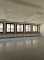 empty office room, white walls, large windows, gray floors, white ceiling