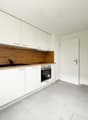 White kitchen, wooden counter, white appliances, large windows