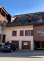 3 story house, beige and brown exterior, 2 garages, stairs, car parked