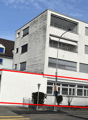 multi-story building, white walls, glass windows, streetlight, garage
