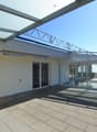 covered balcony with wooden floor, glass walls, metal railings