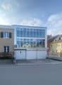 3-story building with a garage in front and glass windows.