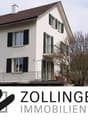 2-storey house, white walls, brown roof, 5 windows, balcony