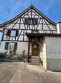 3 story house, white walls, brown trim, green windows, driveway in front