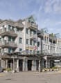 multistory residential building, many balconies, glass entrance canopy, sign reading Die Post