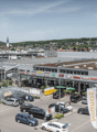 Modern building with parking area, sign indicating Migros store