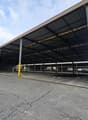 Metal roofing, columns, wide open space, paved floor, yellow road lines