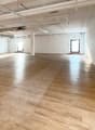 Empty room, wooden floor, bright sunlight, white walls, two glass doors, utility area