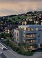 Modern apartment building with multiple floors, balconies, and a rooftop terrace.