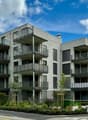 4-storey apartment building, balconies, concrete construction, solar panels, green rooftops