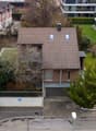 House with brown roof, garage, driveway, garden, neighboring houses
