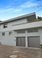 Two-story house, white exterior, two garages, balcony, staircase, driveway