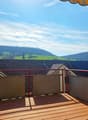 wooden deck, red railing, view of mountains and houses