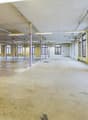 spacious warehouse, concrete floor, large windows, metal columns