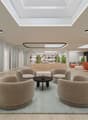 Spacious lobby area with modern, minimalist design. Beige armchairs and a round coffee table arranged in a seating area. Tall windows along the walls, providing natural light. Recessed lighting fixtures in the ceiling. Potted plants and other decor elemen