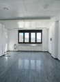 empty room, white walls, gray floor, large window, radiator
