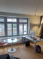 office room with desk, chairs, computer, books, storage boxes, shelves, radiator, window