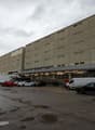 multi-storey building, parking lot, grey exterior, multiple windows, parked cars