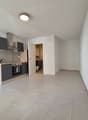 Empty kitchen, white tiles, wooden cabinets, built-in oven, countertop, sink, white walls