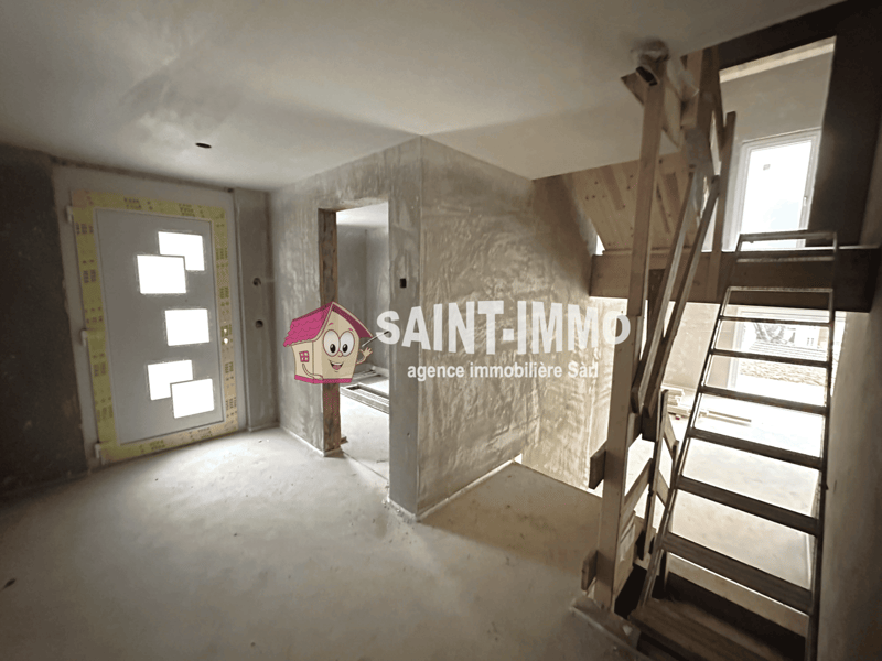 The image shows an unfinished apartment interior with drywall and construction materials visible. The Saint-Immo real estate agency logo is prominently displayed on the wall, indicating this is a property being marketed by that agency.