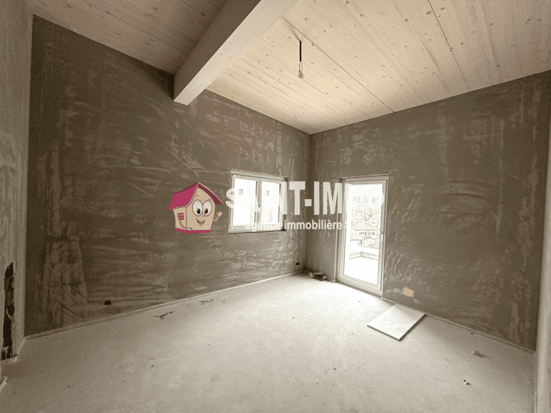 Unfinished room with drywall walls, wooden ceiling, and a window. The room appears to be in the construction or renovation stage.