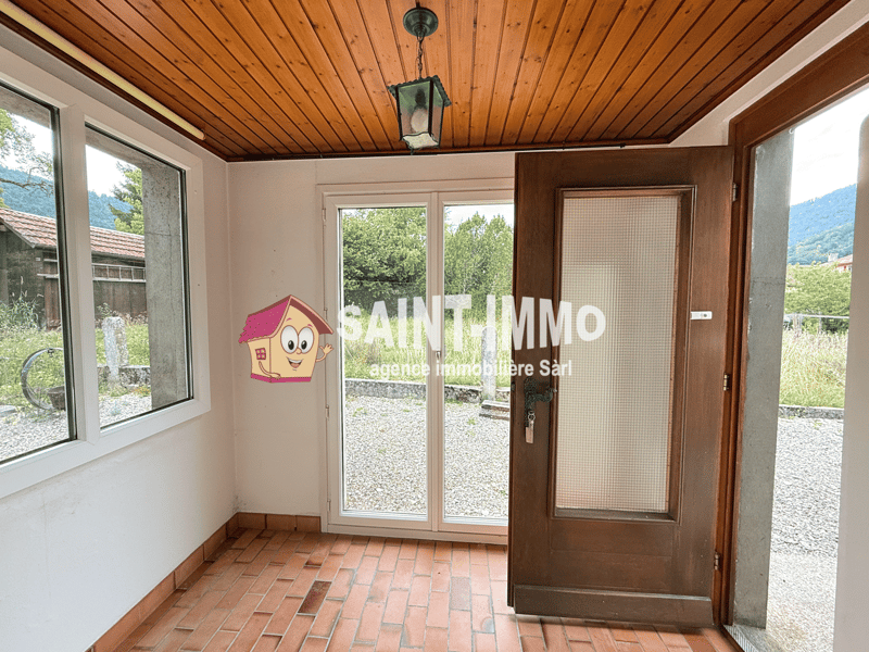 Empty room, wooden ceiling, brick floor, white walls, sliding glass door, key hanging on door