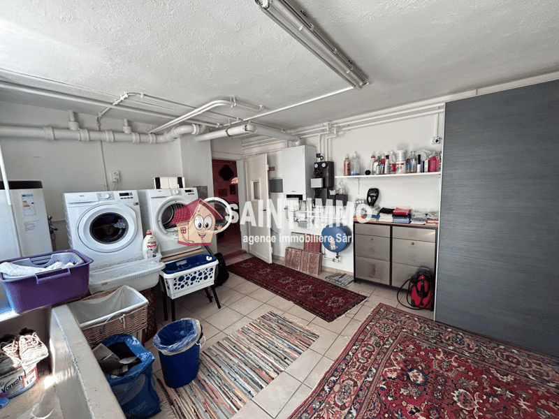 Laundry room with washing machine, dryer, shelves, and various household items and storage containers