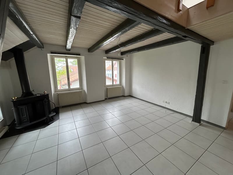 empty room, white tiles, wooden beams, fireplace, radiators, windows