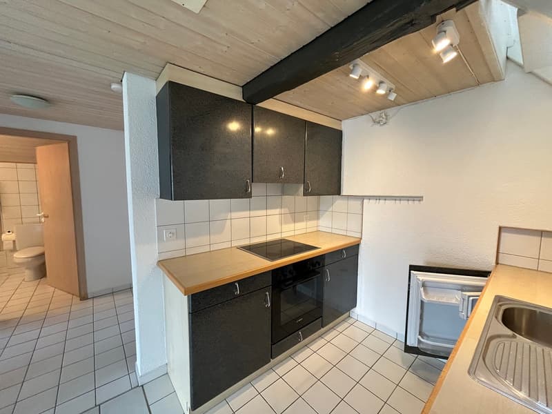 modern kitchen with wooden countertops, black cabinets, integrated oven and stove, sink, and dishwasher