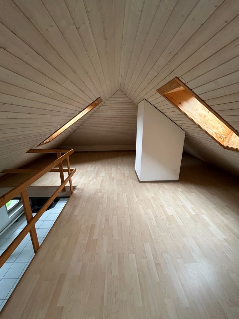 empty attic room, wooden floor, wooden ceiling, two skylights, white wall, wooden railing