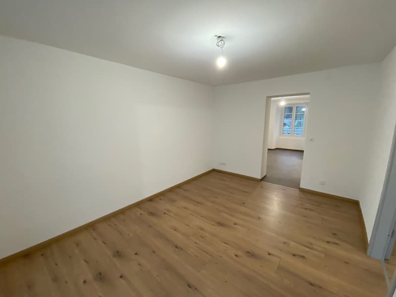 empty room, wooden floor, white walls, open door to another room, light