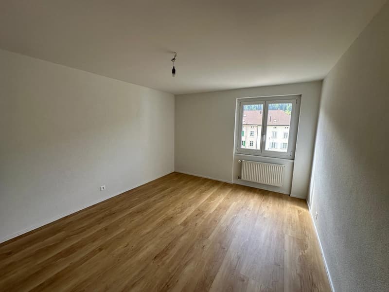 empty room, wooden floor, white walls, window with view, white radiator