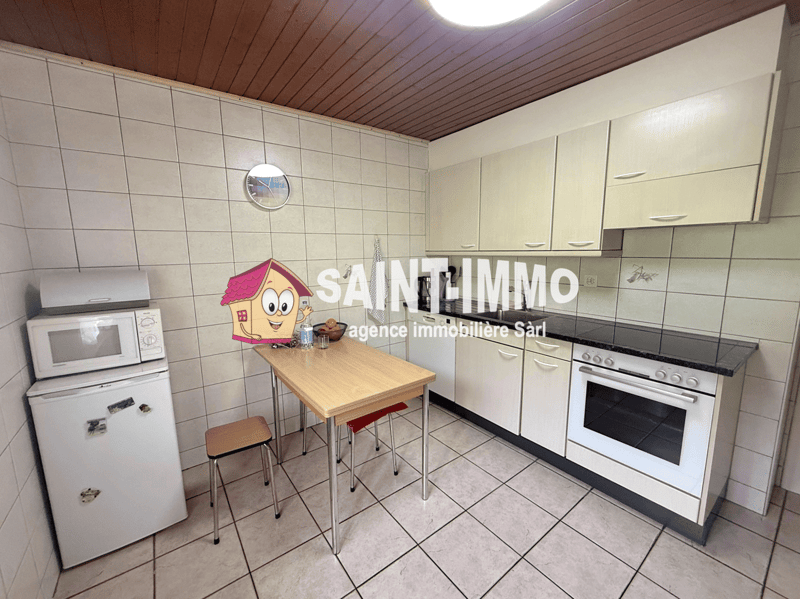 kitchen with white tiles, white cabinets, black countertop, white oven, microwave, refrigerator, wooden table, stools