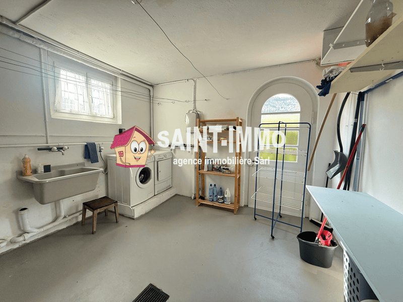 Laundry room with washing machine, dryer, sink, shelves, and cleaning tools