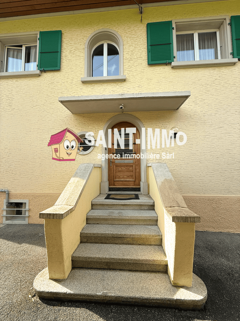 yellow house, green shutters, wooden door, steps leading to the entrance, surveillance camera