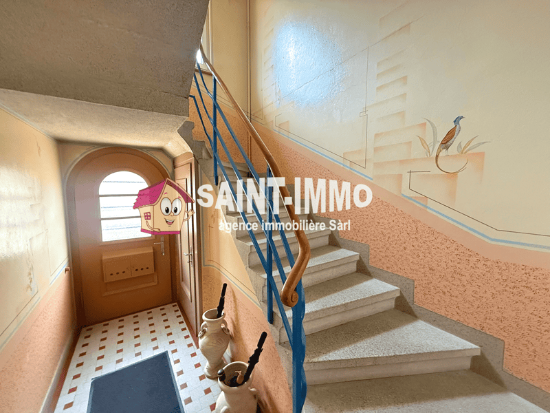 Staircase with blue handrail, white tiles, wooden door, decorative vases, and a blue mat.