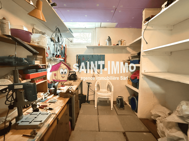 Workshop with tools, shelves, workbench, chair, and a window