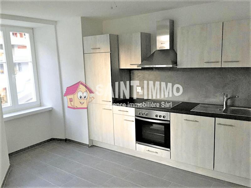 Modern kitchen with white cabinets, black countertops, stainless steel appliances, and tiled flooring.