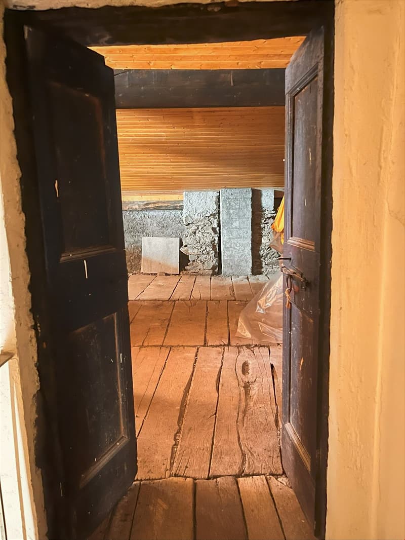 Open wooden door, wooden floors, stone wall