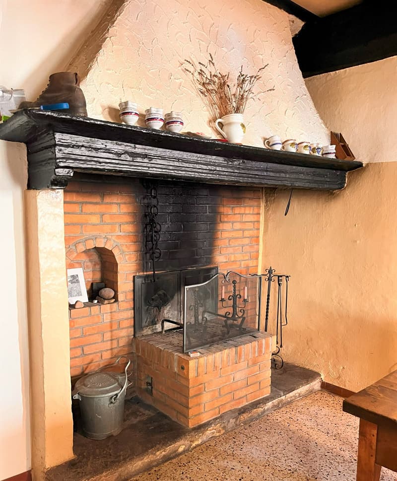 Large fireplace, brick wall, glass window, table, candle holder